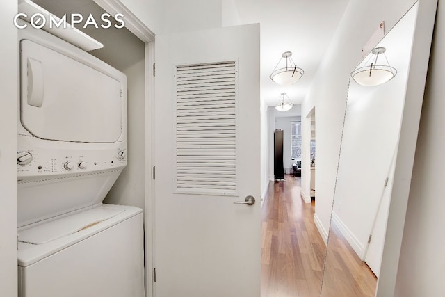 clothes washing area with stacked washer and dryer and light hardwood / wood-style floors