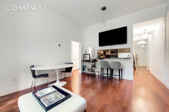 living room with dark wood-type flooring and a towering ceiling