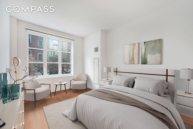 bedroom featuring wood finished floors, visible vents, and baseboards