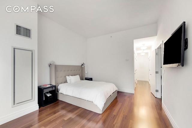 bedroom featuring wood finished floors and baseboards
