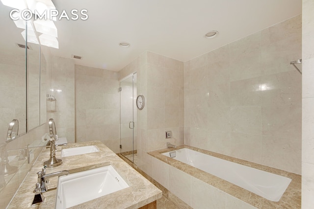 bathroom featuring visible vents, double vanity, a sink, a shower stall, and a bath