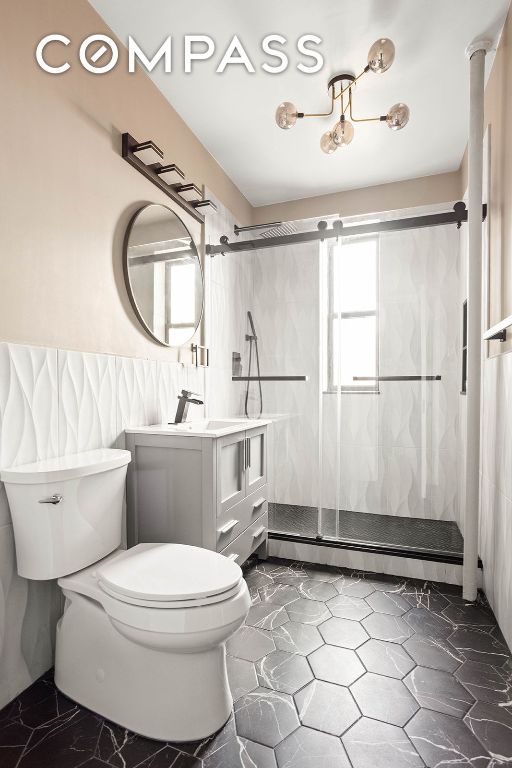 bathroom featuring vanity, a baseboard heating unit, toilet, and tiled shower