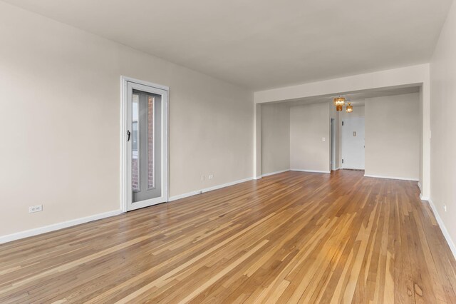 unfurnished room featuring light hardwood / wood-style floors and a notable chandelier