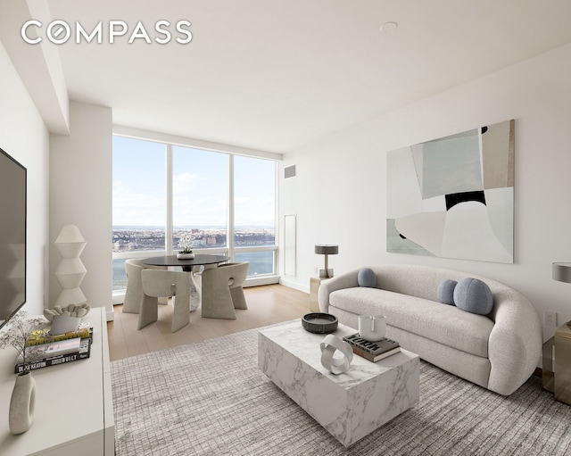 living area with wood finished floors, visible vents, and floor to ceiling windows