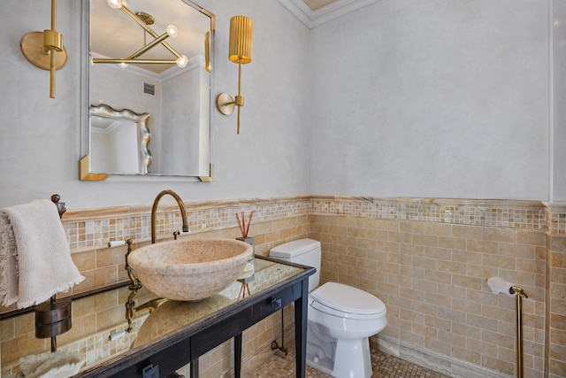 bathroom with ornamental molding, vanity, toilet, and tile walls