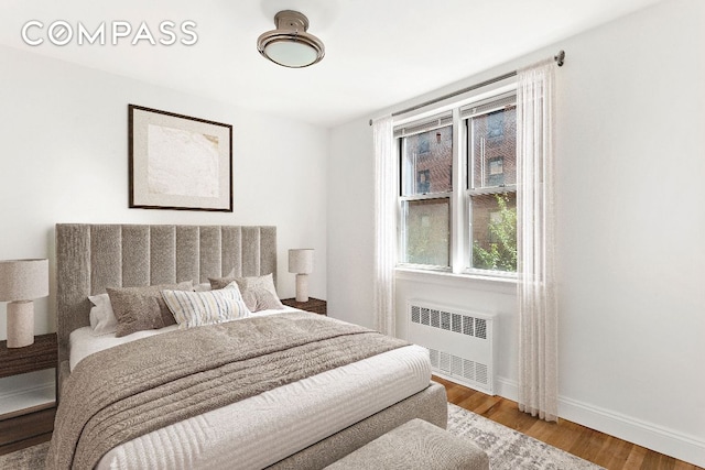 bedroom featuring wood-type flooring and radiator