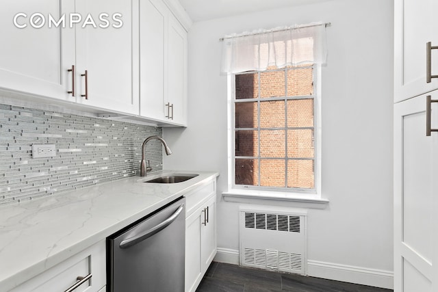 kitchen with radiator, decorative backsplash, stainless steel dishwasher, white cabinetry, and a sink