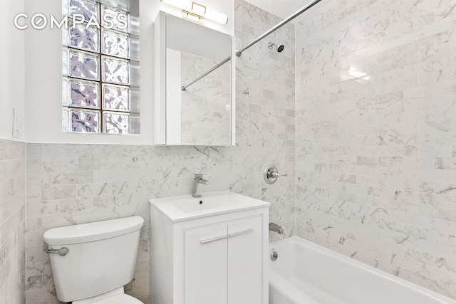 full bath with vanity, shower / bathing tub combination, toilet, and tile walls