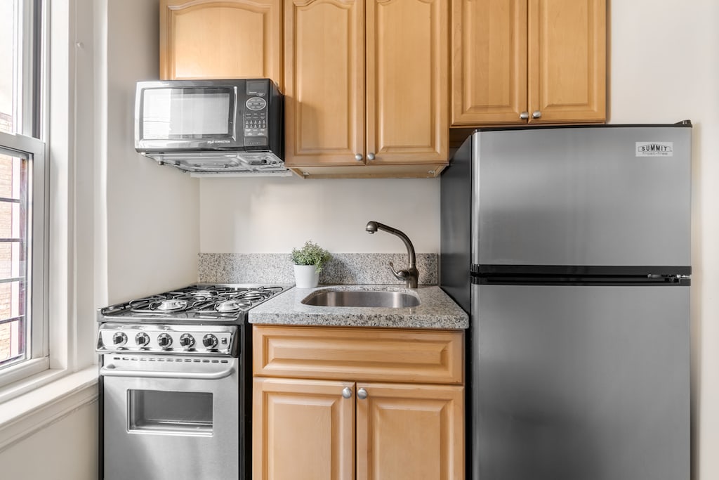 kitchen featuring stainless steel appliances, plenty of natural light, a sink, and light brown cabinets