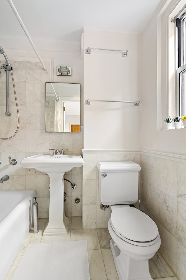 full bathroom featuring  shower combination, tile patterned floors, toilet, and tile walls