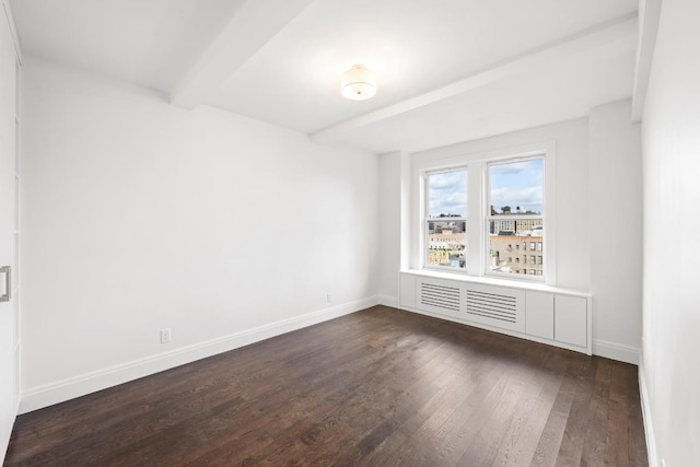 unfurnished room featuring beamed ceiling and dark hardwood / wood-style flooring