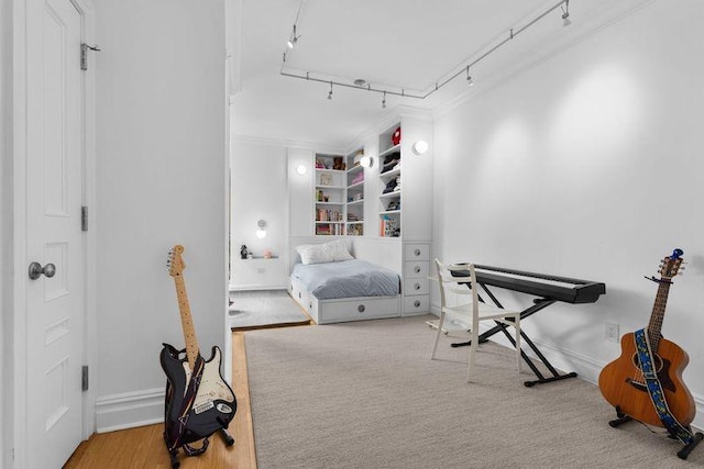 bedroom featuring baseboards, track lighting, and crown molding