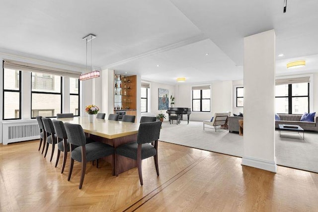 dining area featuring radiator heating unit and parquet flooring