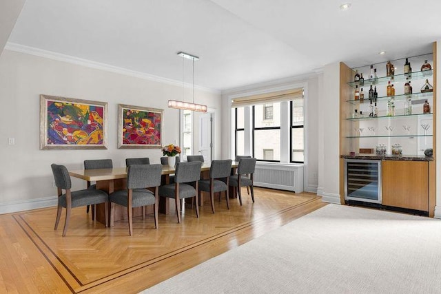 dining room featuring bar, wine cooler, radiator, crown molding, and baseboards