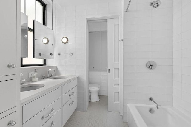 full bathroom featuring a healthy amount of sunlight, tile walls, and a sink