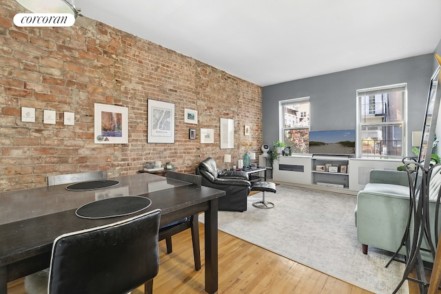 home office featuring brick wall and wood finished floors