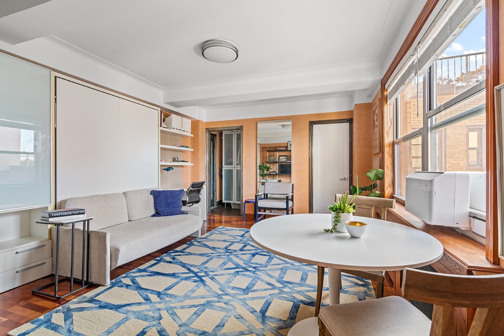 living room with beam ceiling and wood finished floors