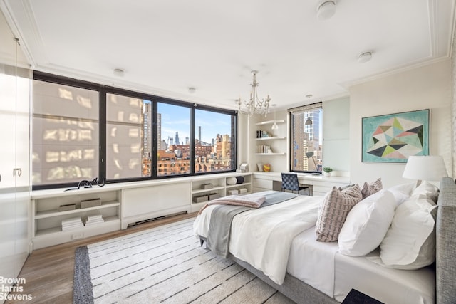 bedroom with crown molding, light wood finished floors, an inviting chandelier, and a city view