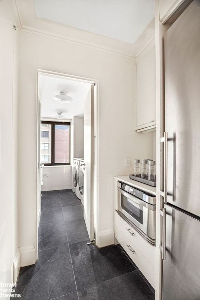 kitchen with baseboards, ornamental molding, independent washer and dryer, and stainless steel appliances