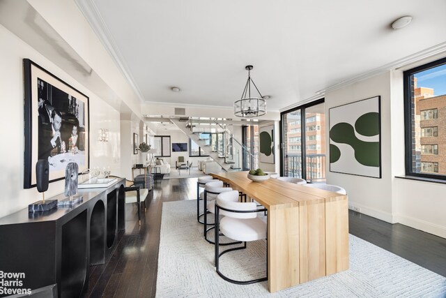 interior space featuring stairway, an inviting chandelier, ornamental molding, and dark wood-style flooring