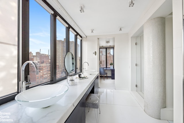 full bathroom featuring a city view, a sink, and double vanity