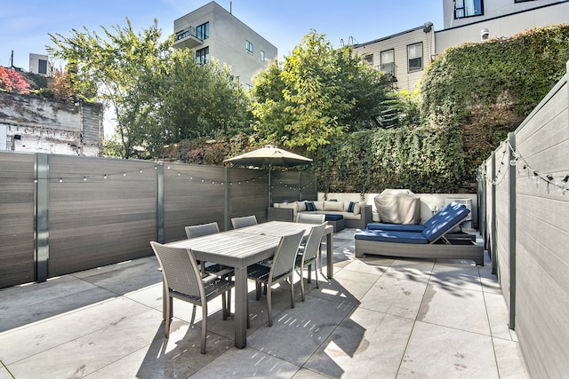 view of patio featuring outdoor dining area, a fenced backyard, and an outdoor hangout area