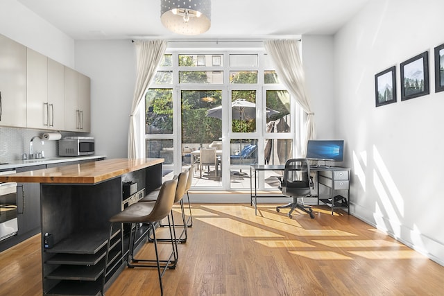 interior space featuring a sink, baseboards, and wood finished floors