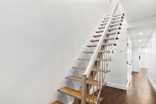 stairway with recessed lighting, wood finished floors, and baseboards