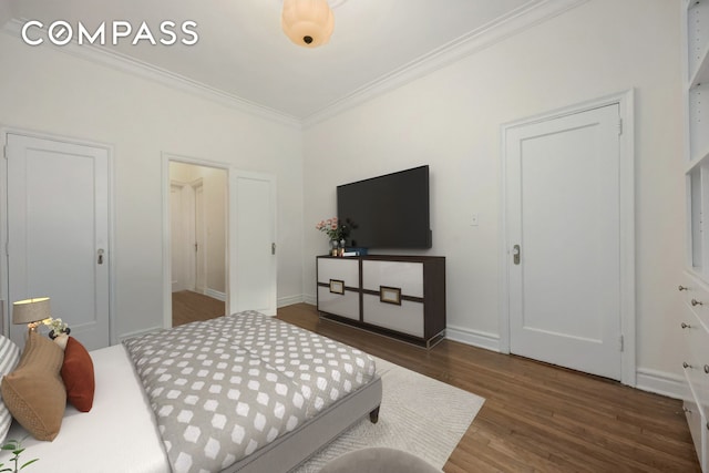 bedroom featuring ornamental molding, baseboards, and wood finished floors