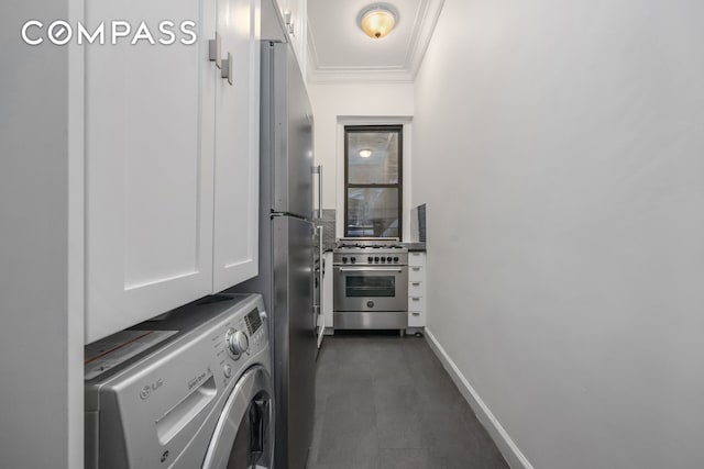 washroom featuring washer / dryer, cabinet space, baseboards, and ornamental molding