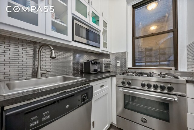 120 E 86th St Unit 3D, New York City, NY 10028 - kitchen with appliances with stainless steel finishes, a sink, tasteful backsplash, and white cabinets