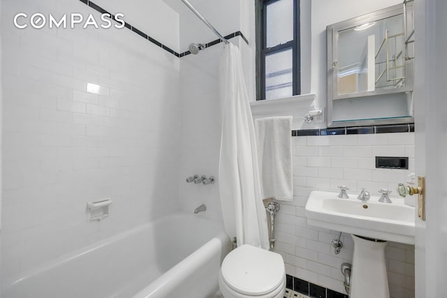 bathroom featuring shower / bath combination with curtain, tile walls, and toilet