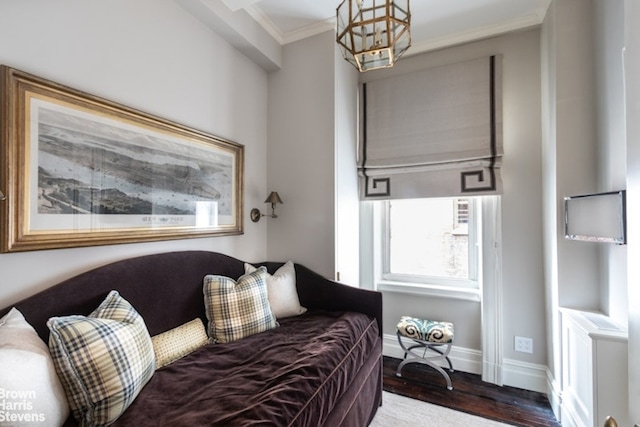 living room featuring an inviting chandelier, crown molding, wood finished floors, and baseboards