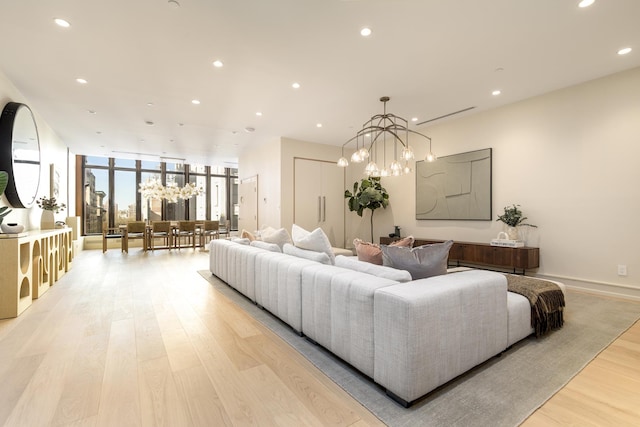 living area featuring baseboards, floor to ceiling windows, light wood-type flooring, a chandelier, and recessed lighting