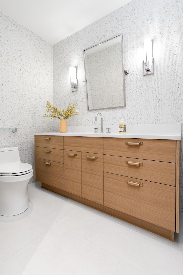 bathroom featuring tile patterned flooring, toilet, and vanity
