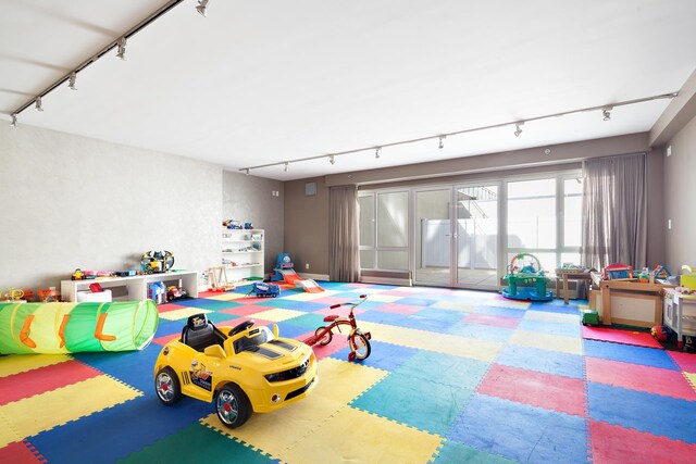 rec room with track lighting and tile patterned floors