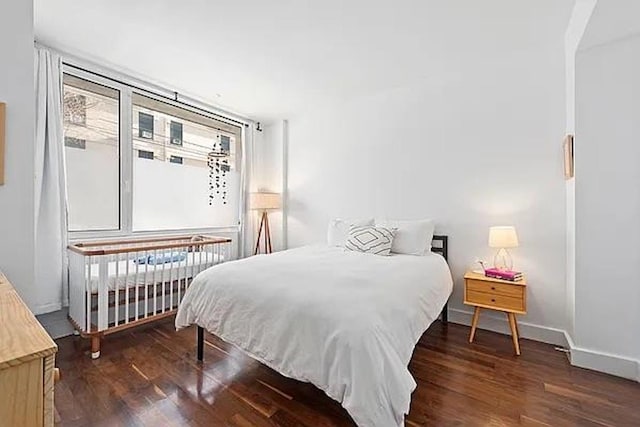 bedroom featuring radiator, baseboards, and wood finished floors