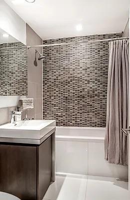 bathroom featuring shower / tub combo, tile walls, and vanity