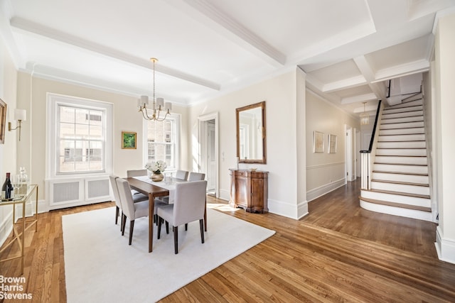 dining area featuring ornamental molding, dark hardwood / wood-style floors, a notable chandelier, and beam ceiling