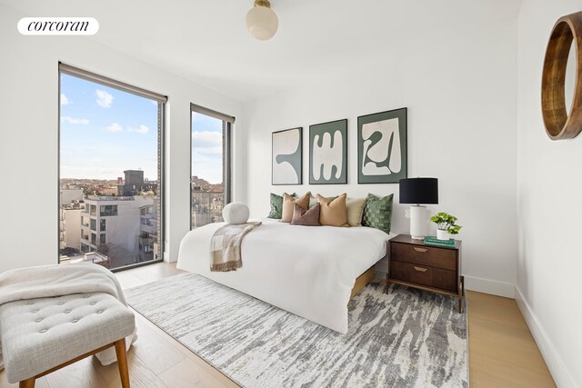 bedroom featuring baseboards, visible vents, and light wood-style floors