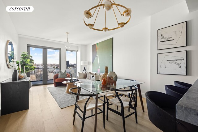 dining area featuring a notable chandelier, light wood finished floors, and visible vents