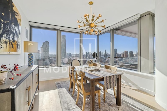 dining area with a view of city, a healthy amount of sunlight, and hardwood / wood-style flooring