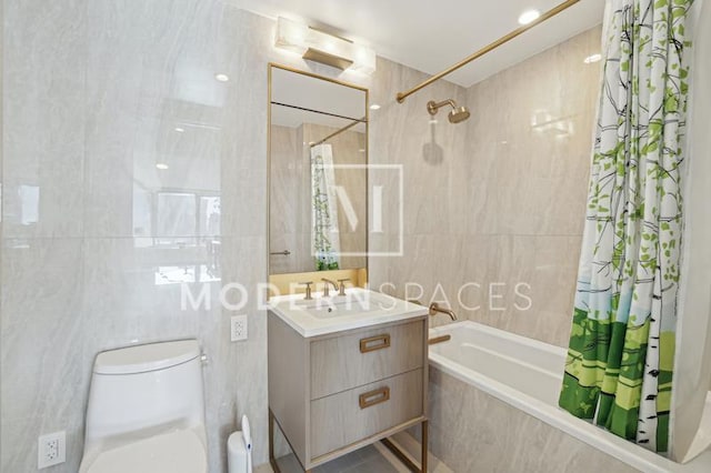 bathroom featuring tiled shower / bath, toilet, tile walls, and vanity