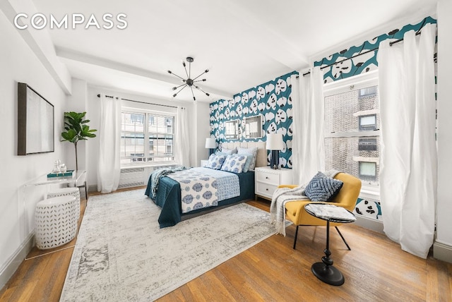 bedroom with hardwood / wood-style floors and a chandelier