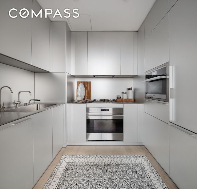 kitchen featuring stainless steel appliances, modern cabinets, and a sink