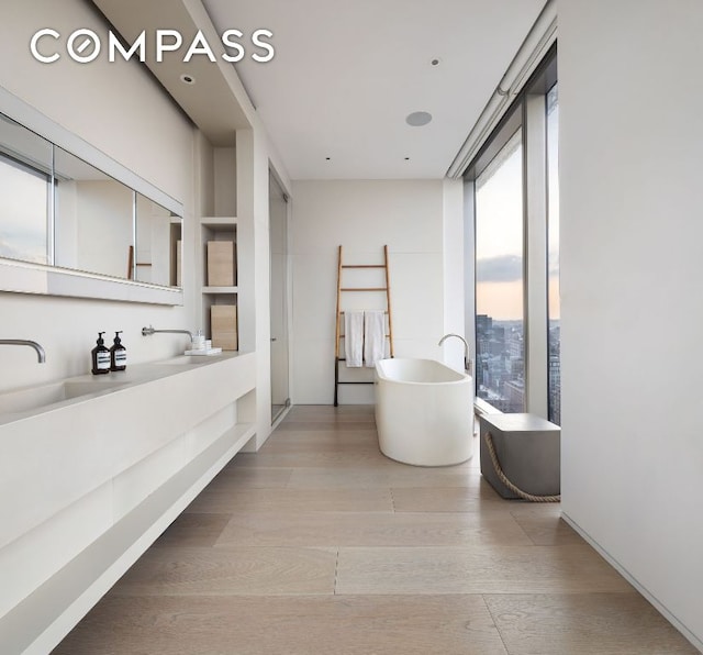 bathroom with vanity, wood finished floors, and a freestanding bath