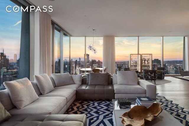 living room with hardwood / wood-style flooring, expansive windows, and a healthy amount of sunlight