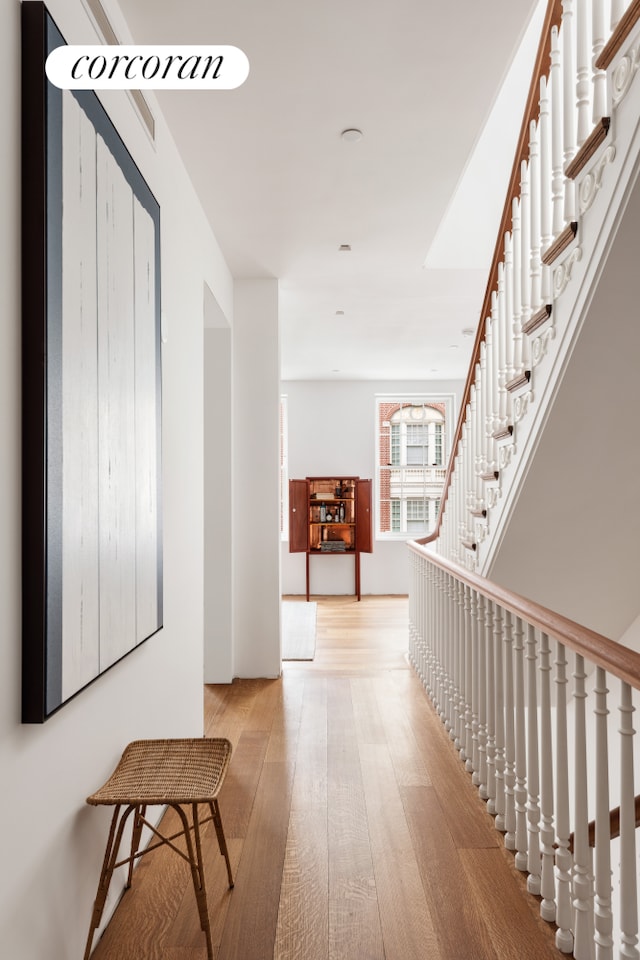 corridor featuring stairs and light wood-style floors