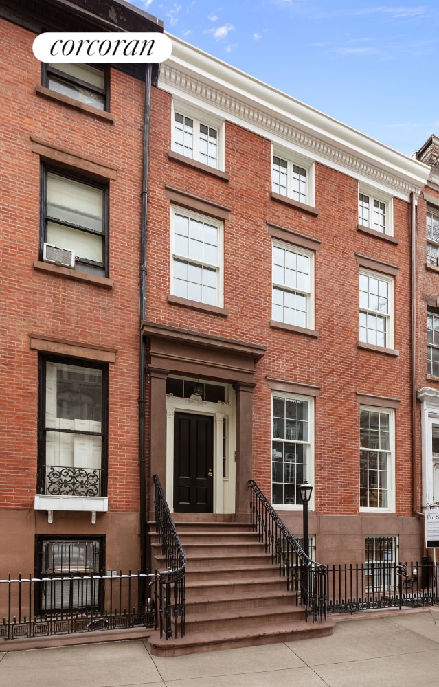 view of front of home featuring brick siding, fence, and entry steps