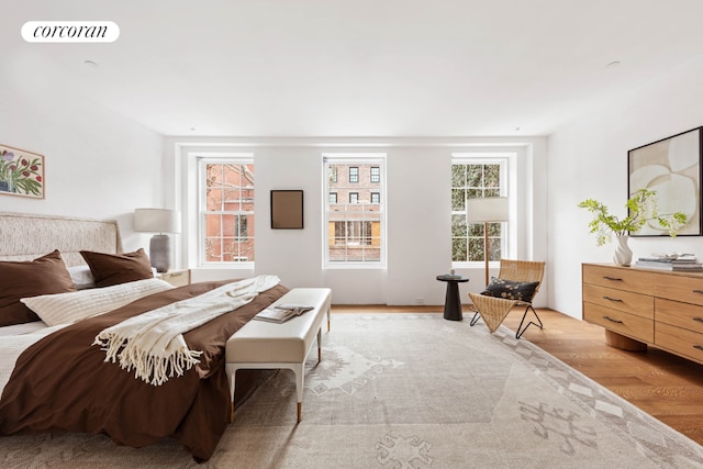 bedroom with light hardwood / wood-style floors and multiple windows